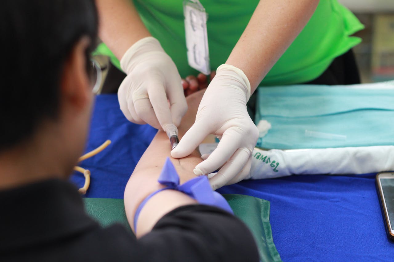 our-services-1 A healthcare professional administering an injection to a patient's arm during a medical procedure.